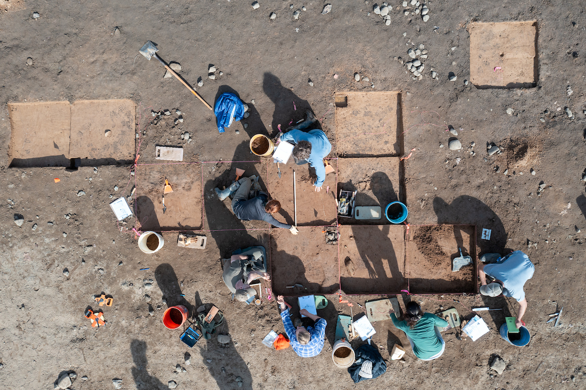 Students work in the field at an archeology site