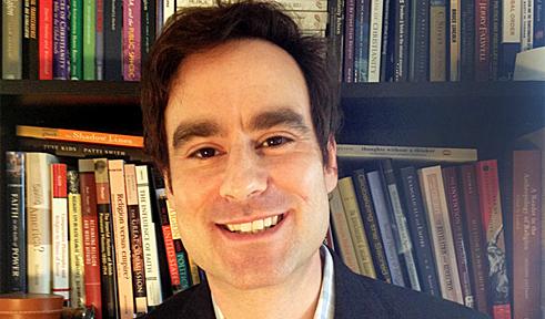 Jonathan Agensky, portrait in front of bookshelves