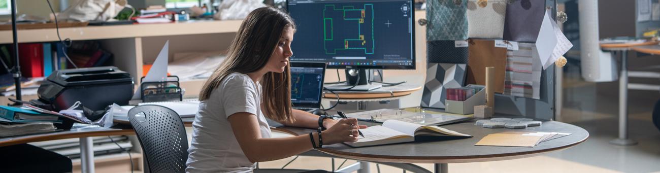 Student working at desk with computer