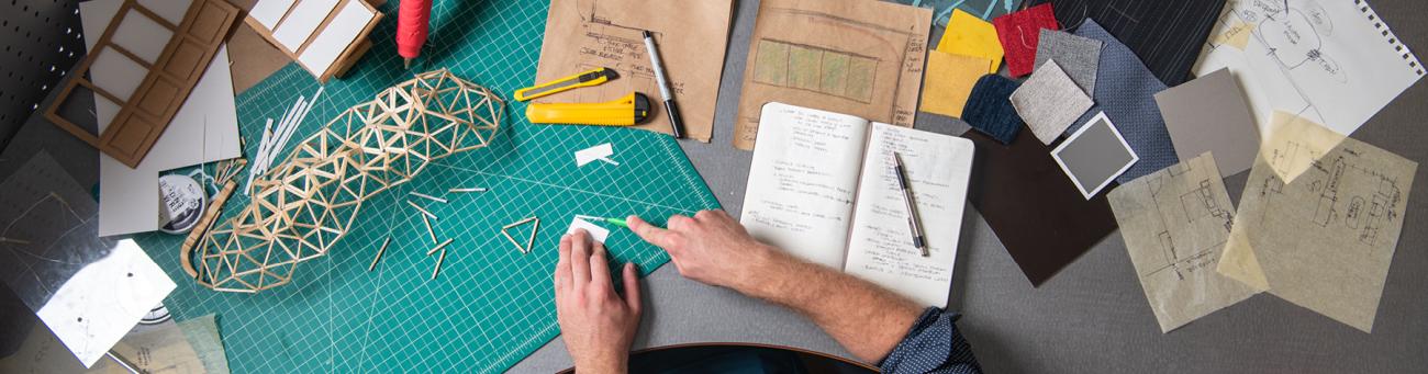 person at desk creating an architectural model