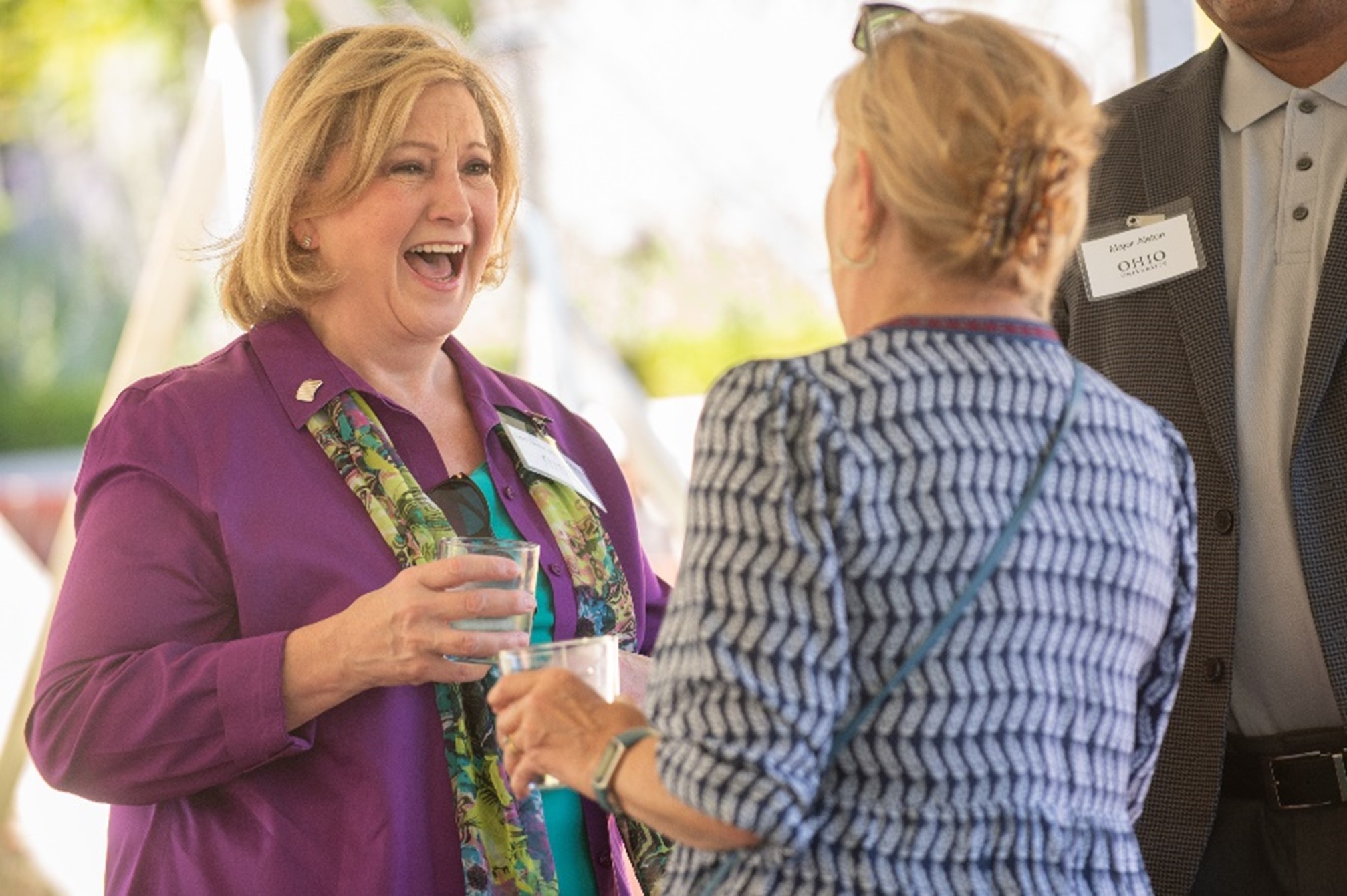 Photo of Dr. Lori Stewart Gonzalez interacting with an attendee at the Books, Gardens and High Tea event