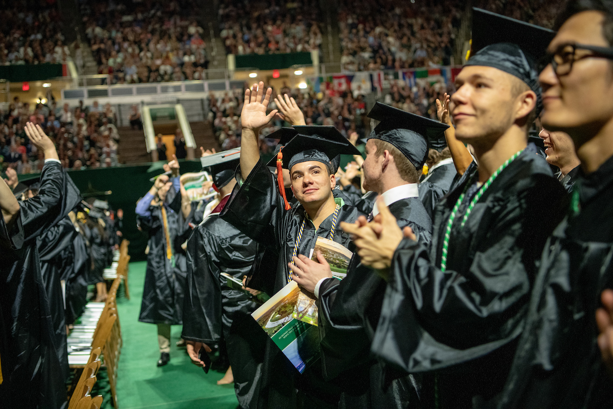 Trent Comfort (Center) waves to supporters during Spring 2019 Undergraduate Commencement. Photo by Ben Siegel