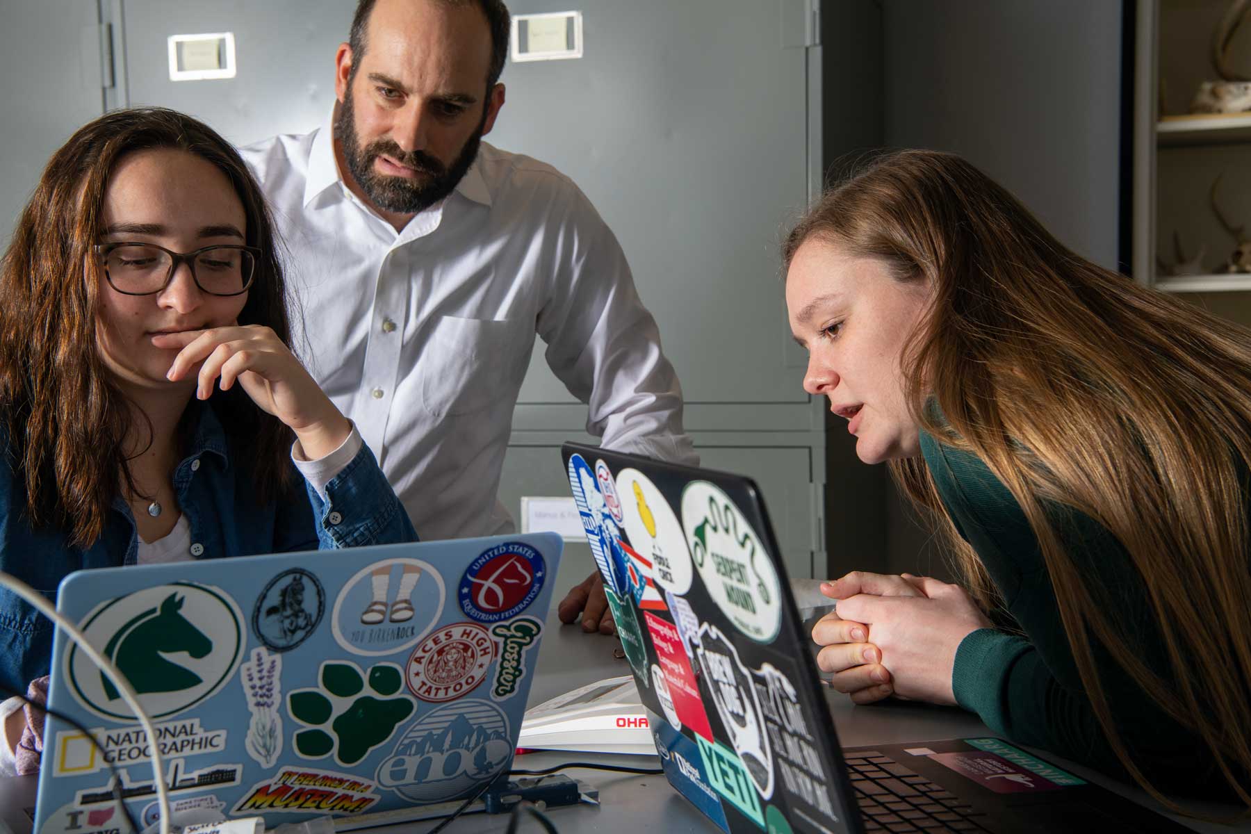Professor Joseph Gingerich analyzing items with his students using laptop computers