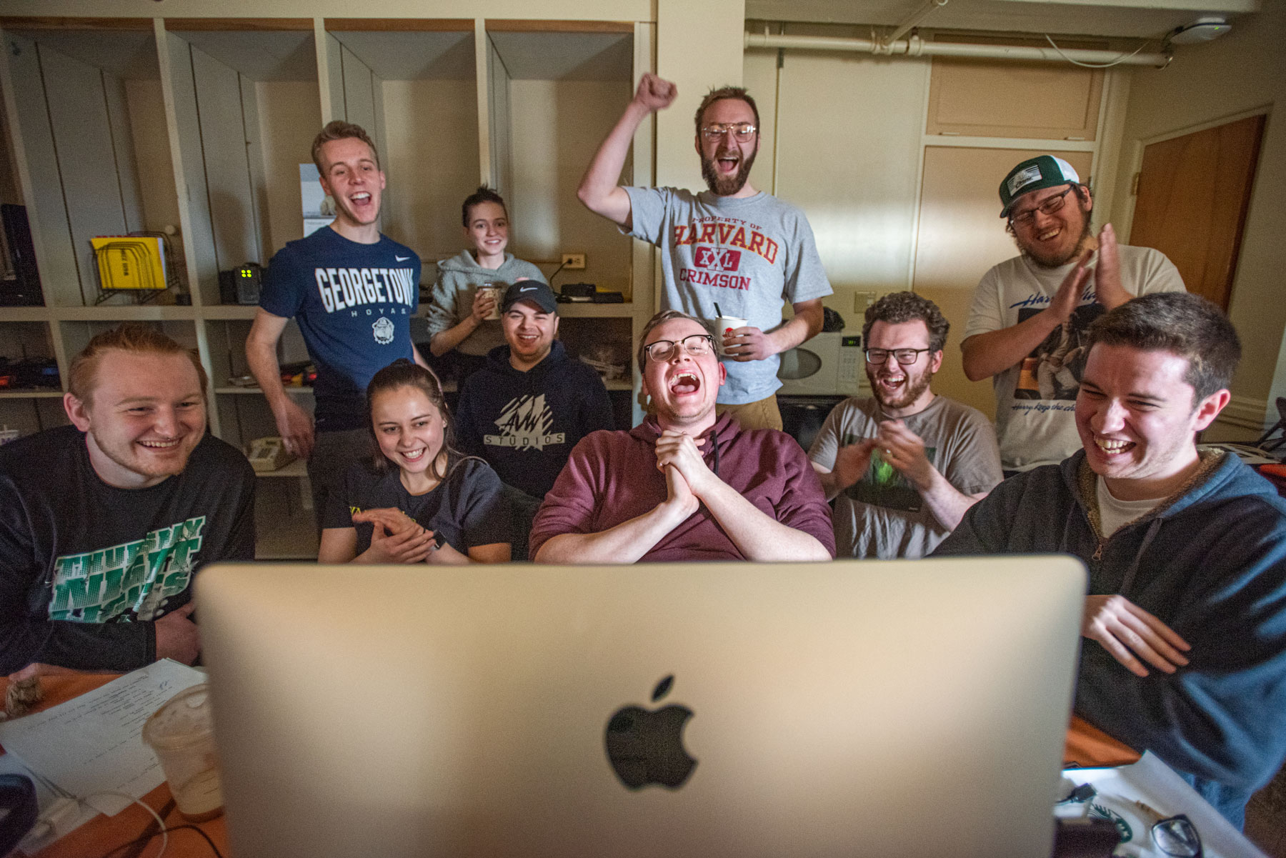 Student team celebrating around a Macintosh computer