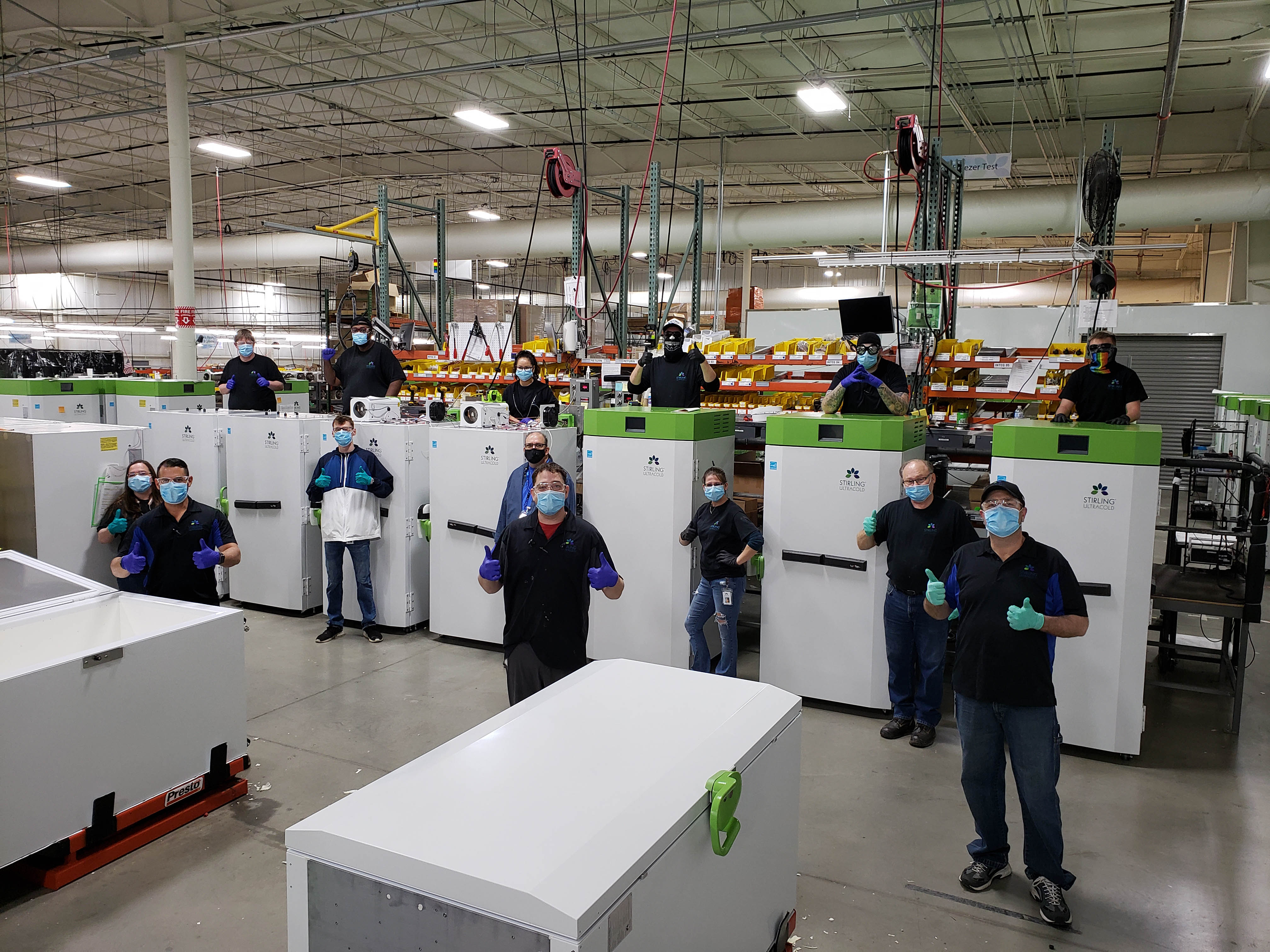 Stirling Ultracold employees stand with the company's freezers.