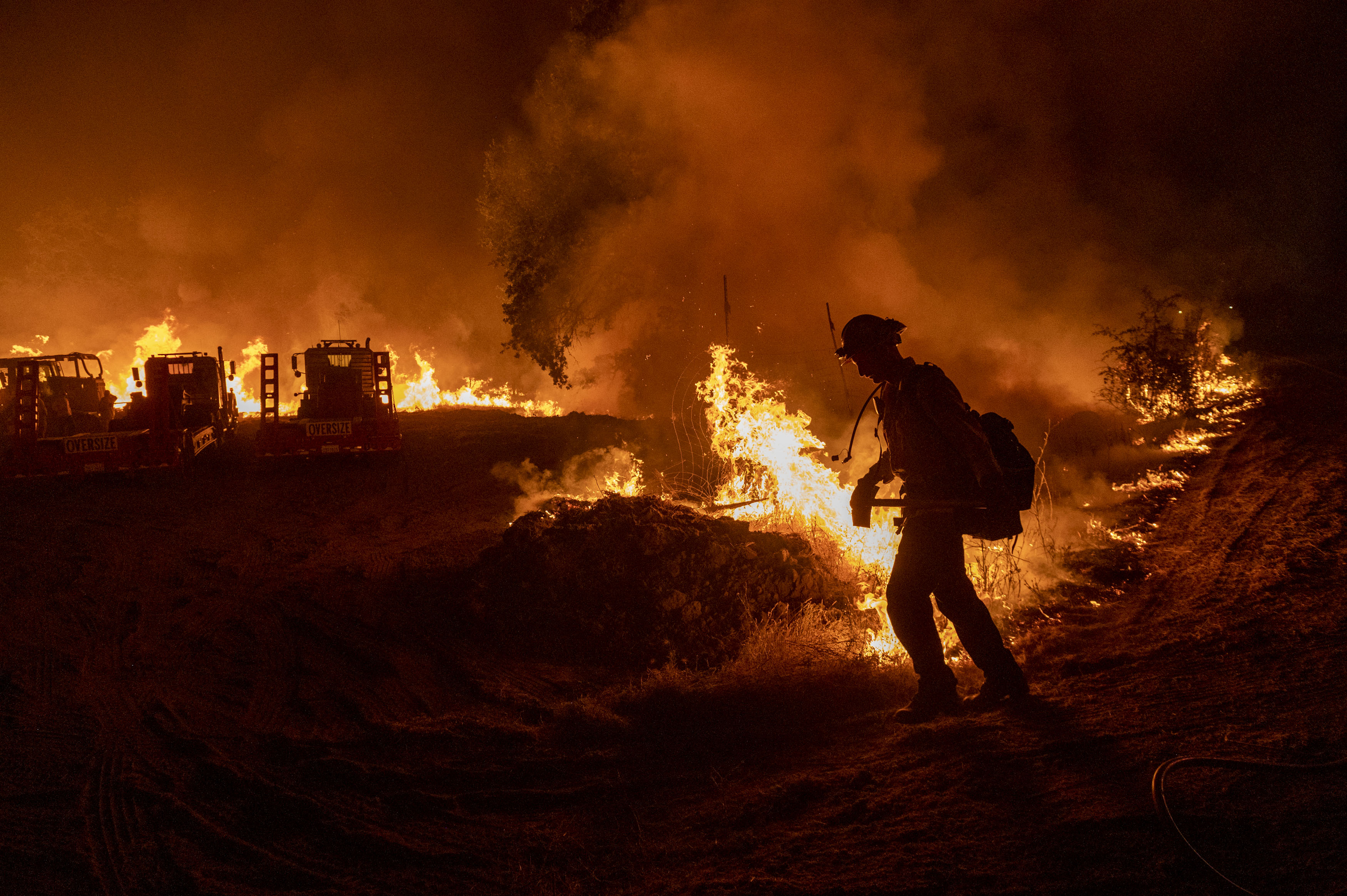 A firefighter battles a blaze in darkness