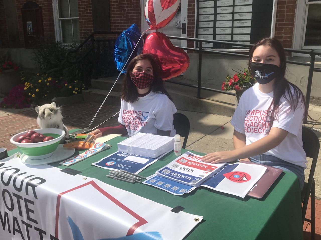 Campus Election Engagement Project Fellows Sarah Donaldson (left) and Reese Campbell share voter information outside the Athens County Courthouse before the November election.