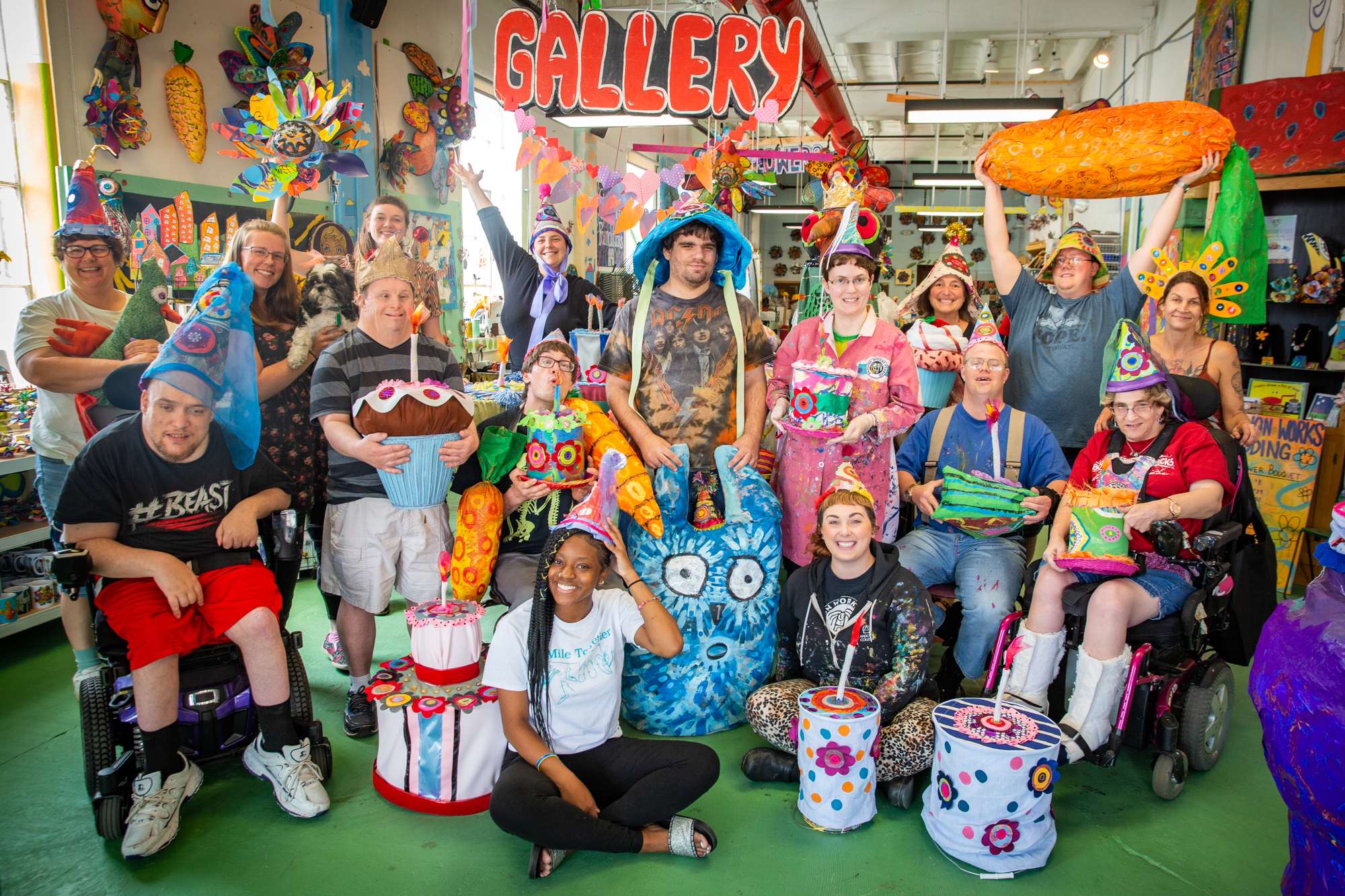 Artists and volunteers pose with their work in Passion Works Studio