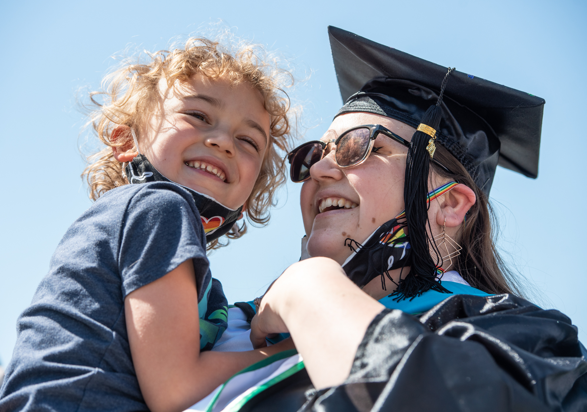 A graduating student holds up a small child