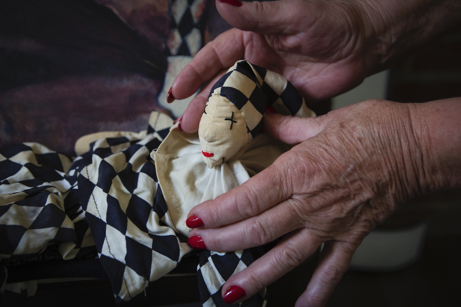 A close up picture of Tilly Berghege's hands holding up a doll she sewed together to create. 