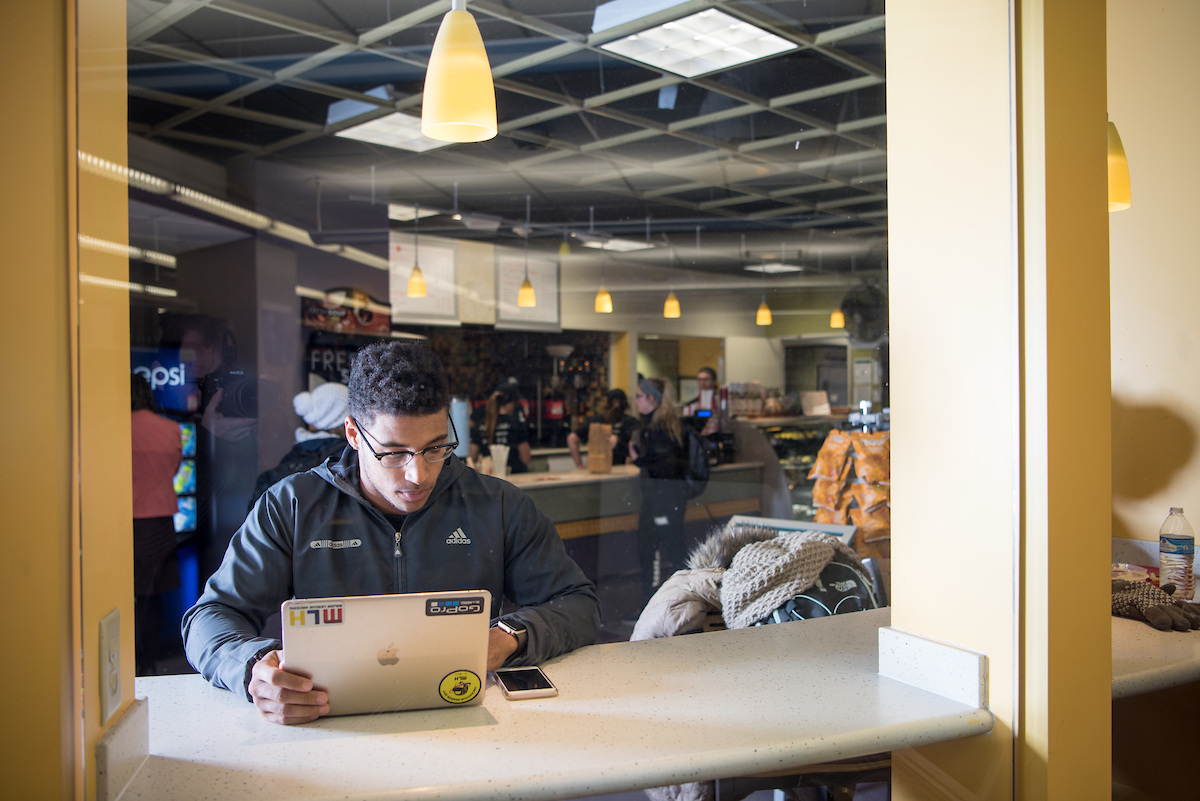 Student studying on their laptop in a cafe