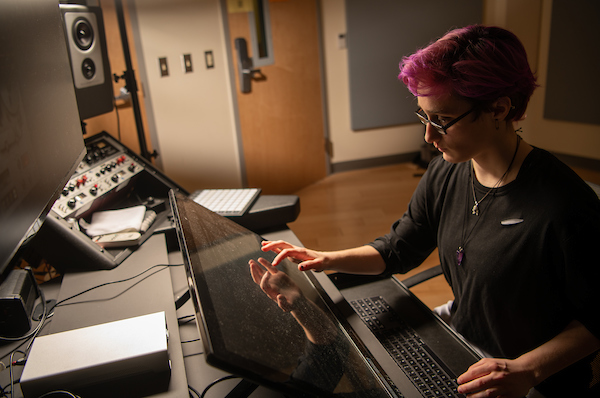 A woman works on mixing music in the studio