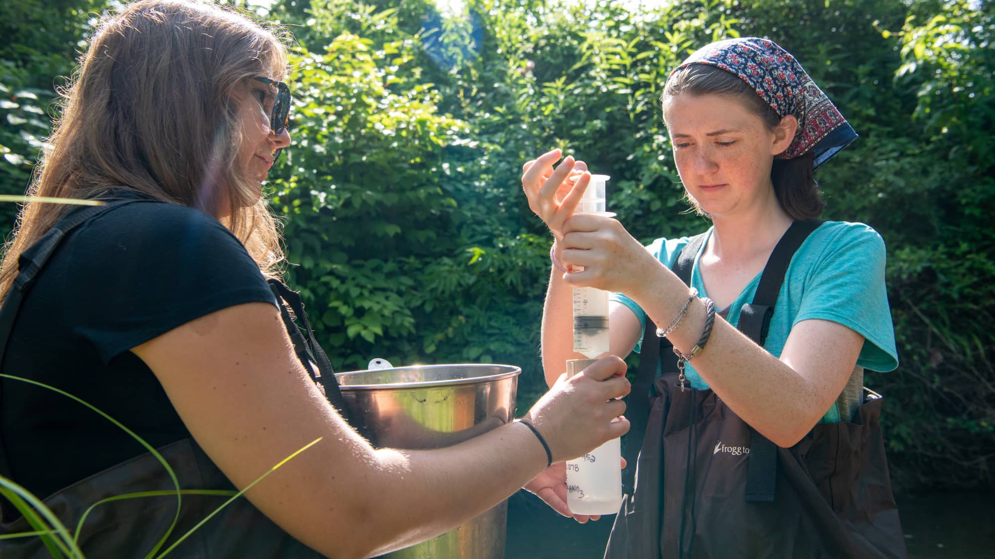 Michelle Shively (left) of Rural Action instructs undergraduate engineering student Liz Myers on how to evaluate stream health at an acid mine drainage site near Athens. 