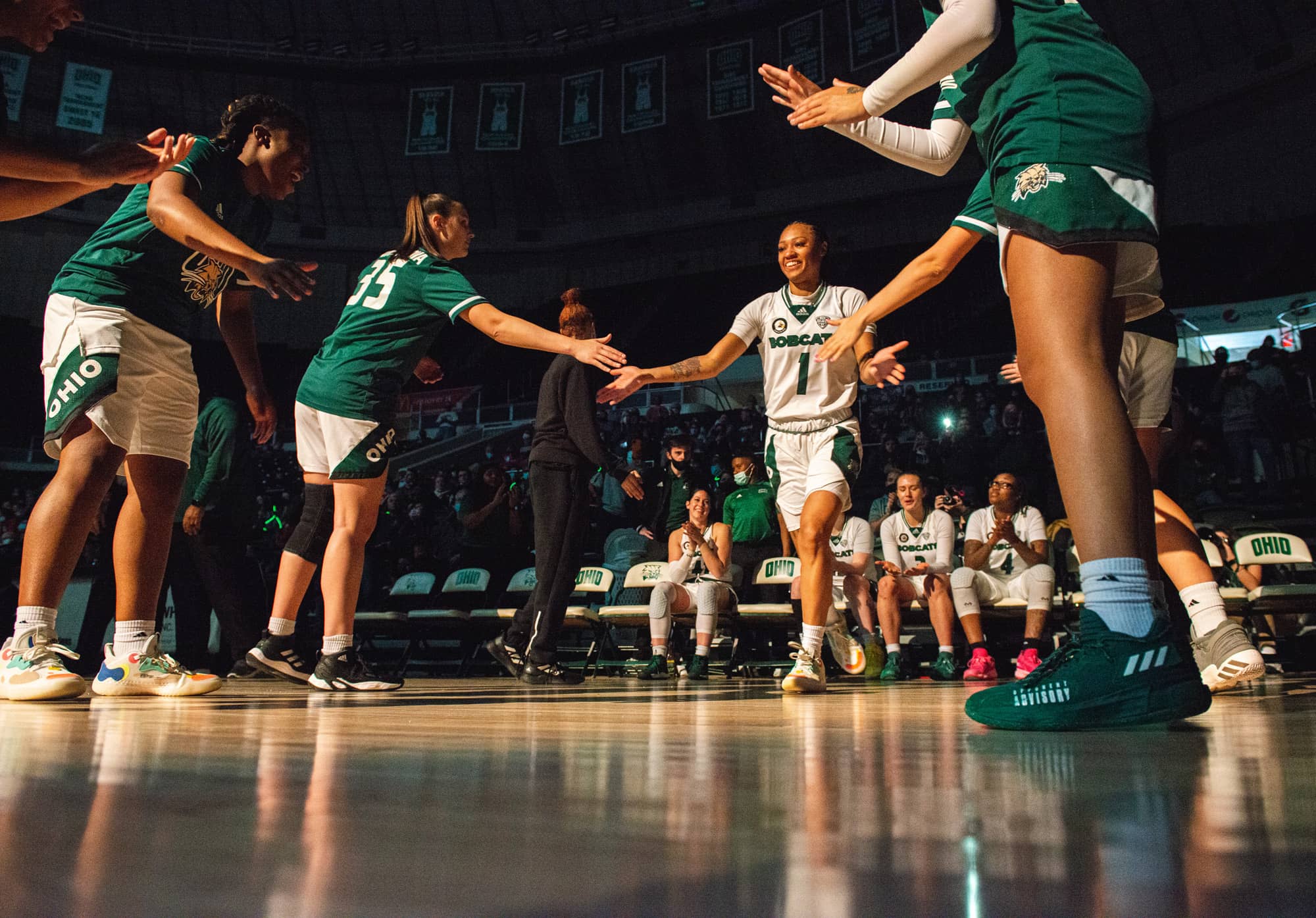 CeCe walking onto a basketball court giving high-fives to her teammates