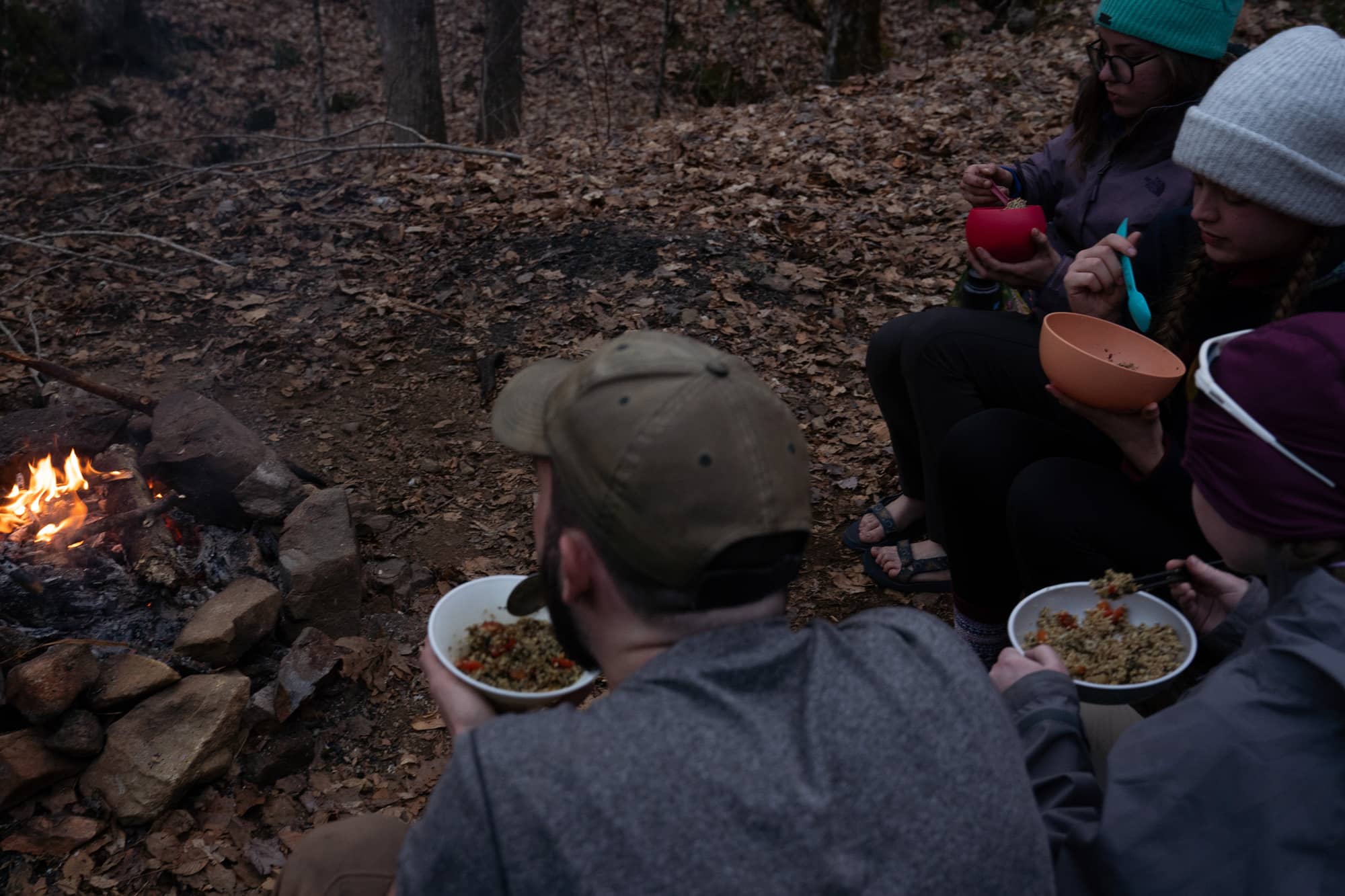 Ohio University students eat quinoa stir fry for dinner by the campfire during their second day backpacking a section of the Appalachian Trail in the Nantahala National Forest on Sunday, March 6, 2022, at the Moore Creek Camp near Franklin, North Carolina.