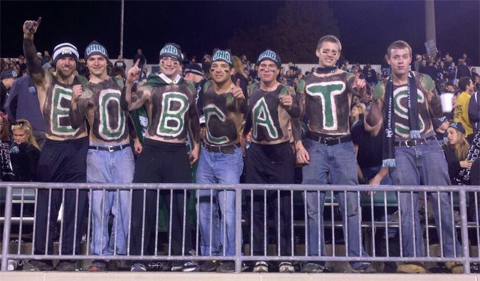 Michael Richard and shirtless friends with "BOBCAT" across their chests at an OU football game