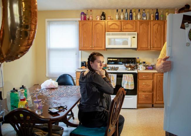 Girl sitting in a moderately lit kitchen