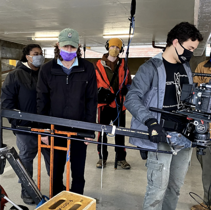 Taylor with their crew setting up a shot inside of a garage