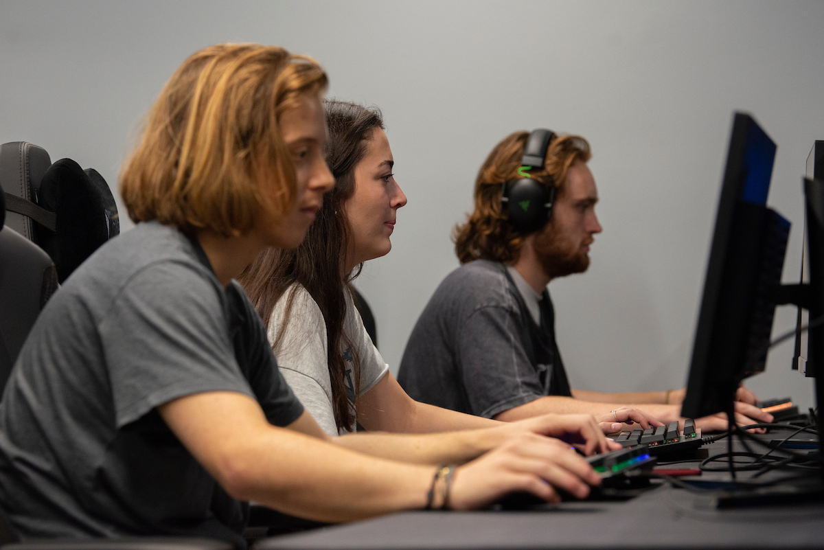 Three students use the computers in the new OHIO Esports Arena
