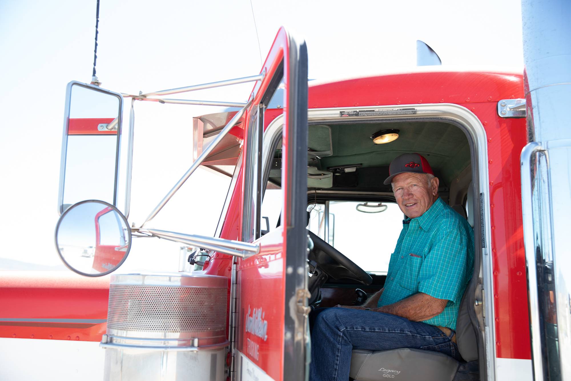 A portrait of Jim Wilkin, 78, owner of Jim Wilkin Trucking, in his favorite truck, a 2000 Peterbilt named “Big Red” in Panaca, Nevada, on Friday, June 10, 2022. “I wouldn’t trade this one for a brand-new one,” said Jim.