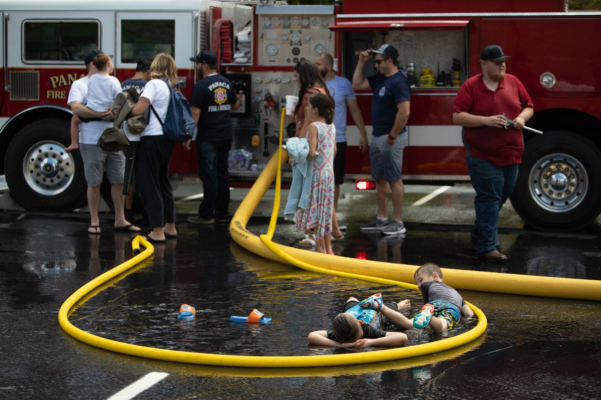 Boys relax in a fire hose pool after the Money Scramble on Saturday, July 23, 2022, in the Lincoln County High School parking lot in Panaca, Nevada.