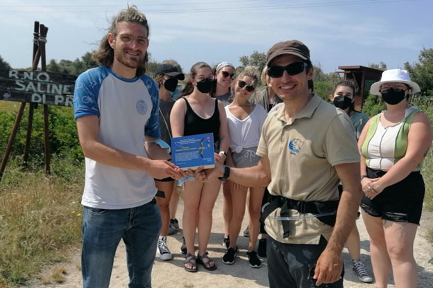 Marco Messina, left, representing Exedra Mediterranean Center, receives an award from guide Federico Militello for the center's support of the nature reserve. Food in Sicily students in the background are left-to-right, Emily Jones, Sydnie Kilgour, Jackie Augustine, Lauren Hayes, Maya Roth-Wadsworth, and Emily McCarty.