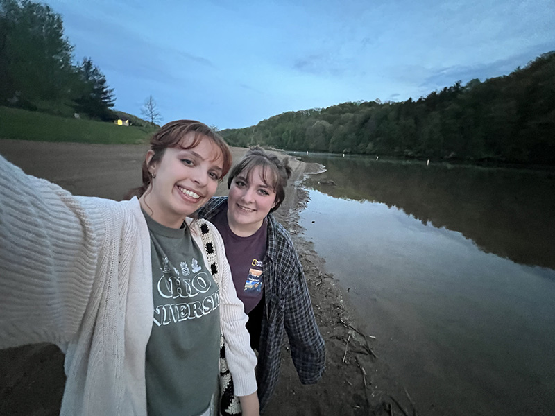 Two students take a selfie photo together outdoors
