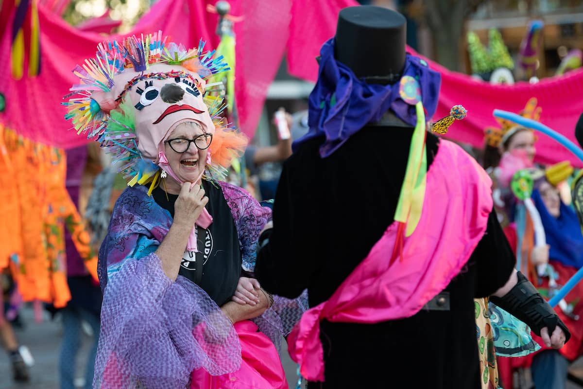 A member of the 2022 Honey for the Heart Parade laughs as they make their way down Court Street in Athens, Ohio.