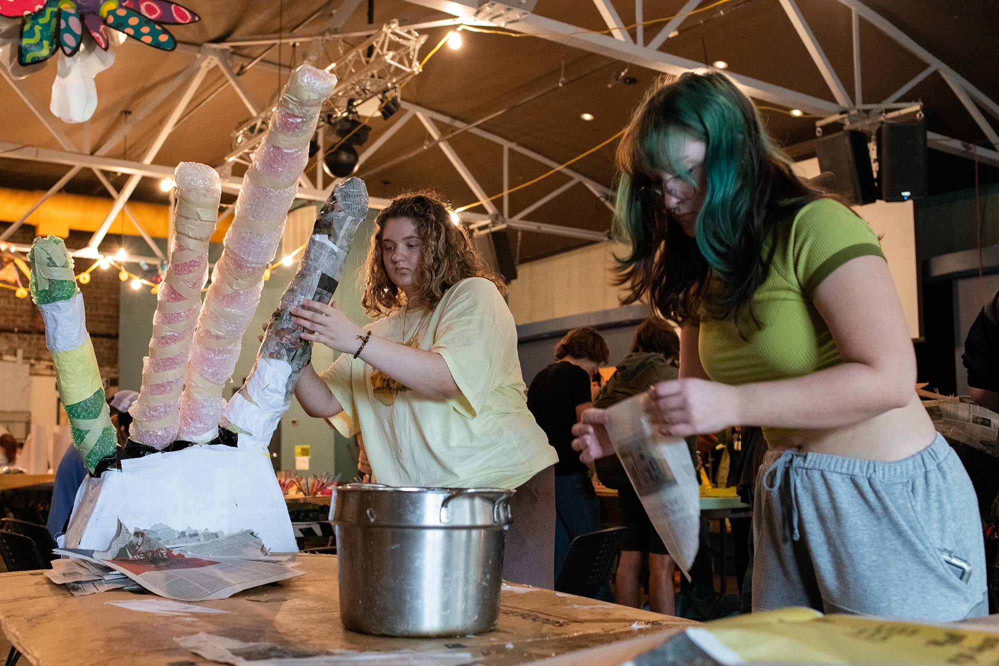 Members of an Ohio University learning community work together at the Central Venue to create paper mache pieces for a costume to be worn in the Passion Works Honey For The Heart Parade in Athens, Ohio.