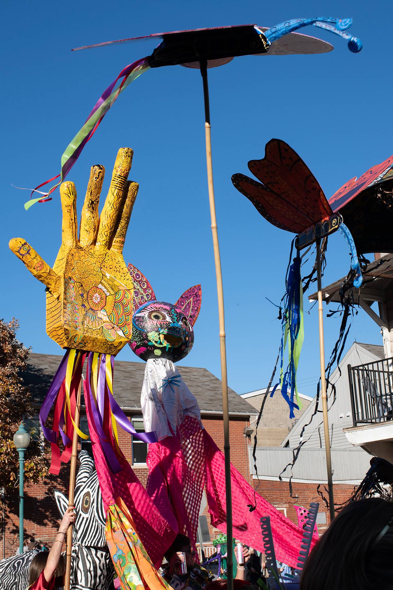 Hand crafted floats are waved through the air during the 2022 Honey for the Heart Parade on Court Street in Athens, Ohio.