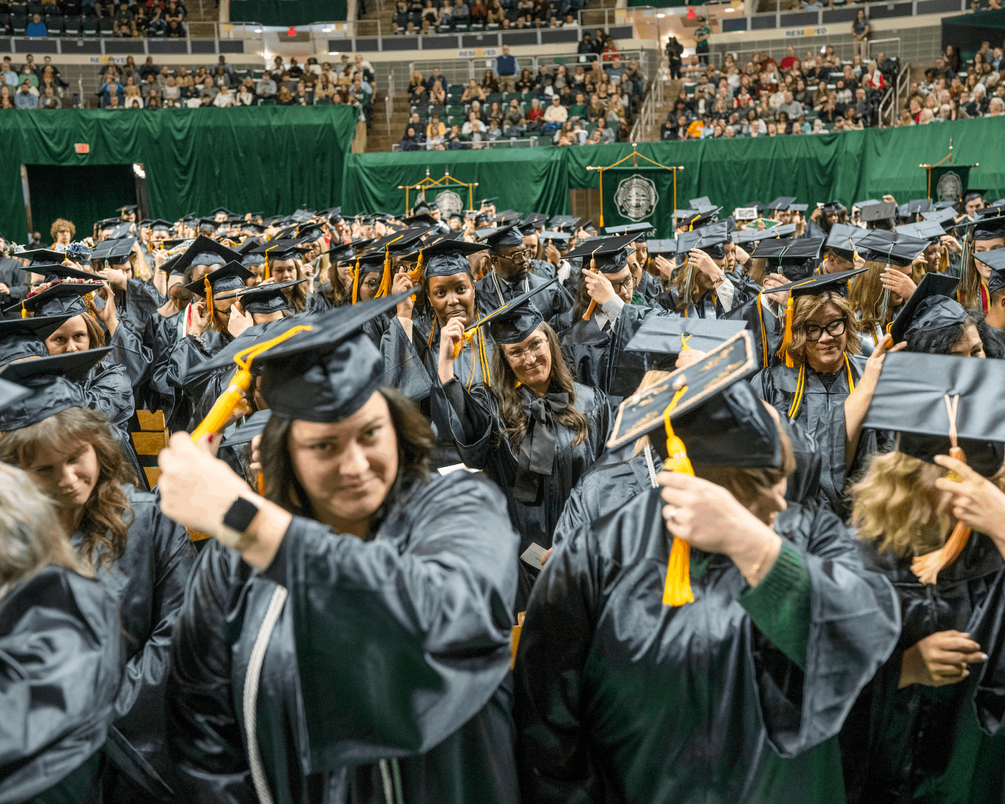 Students move their tassels from the right to the left side of the caps during Fall Commencement. 