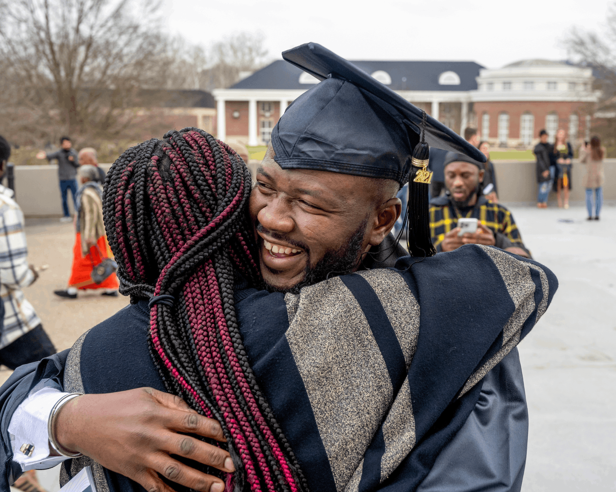A graduate receives a hug following Fall Commencement.