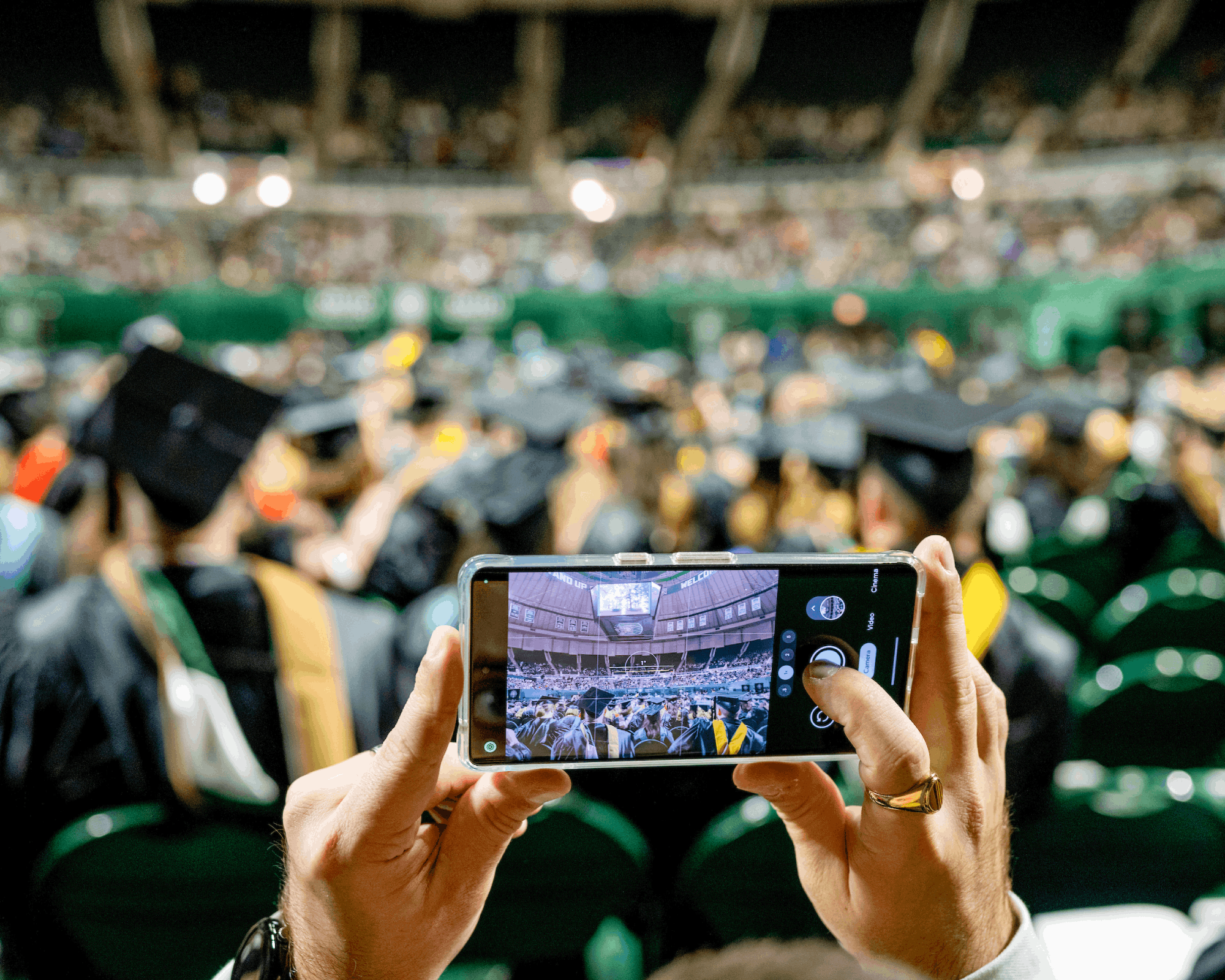 A graduate photographs fall commencement at the Convocation Center. 