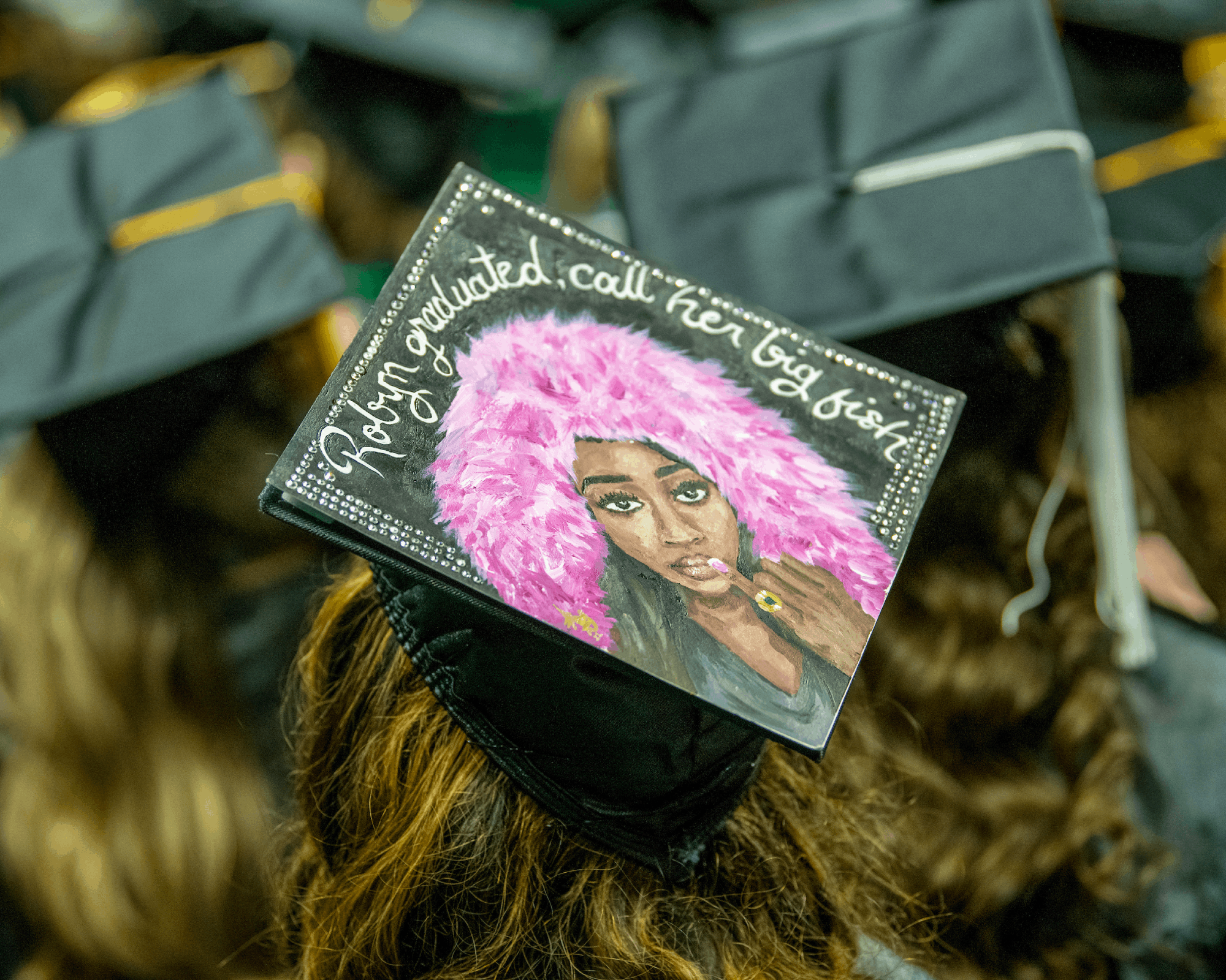 A student decorates their cap for Fall Commencement.
