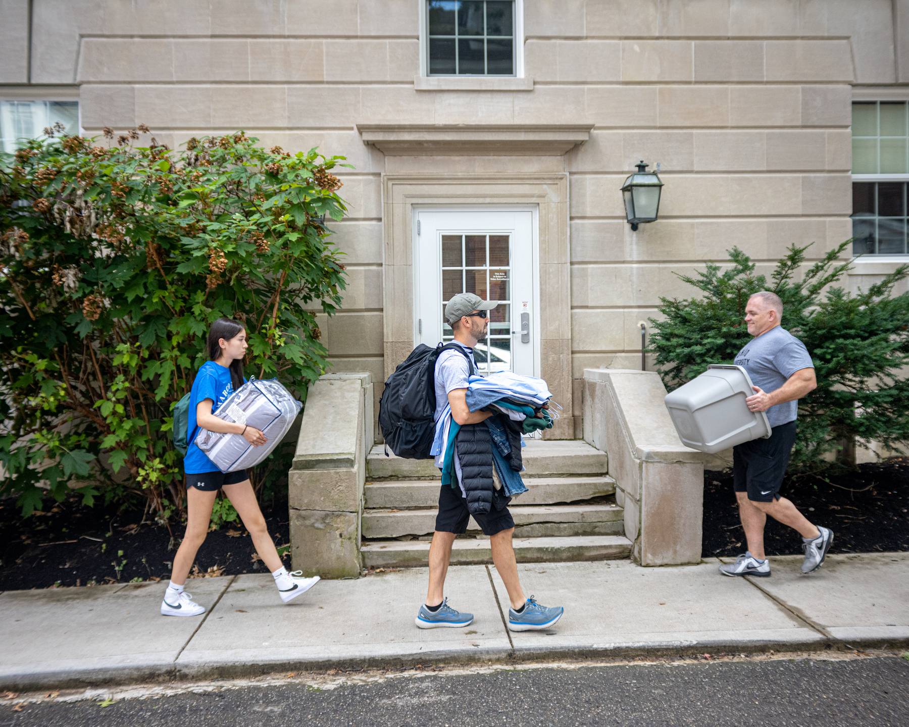 Volunteers and parents help new students move into residence halls.