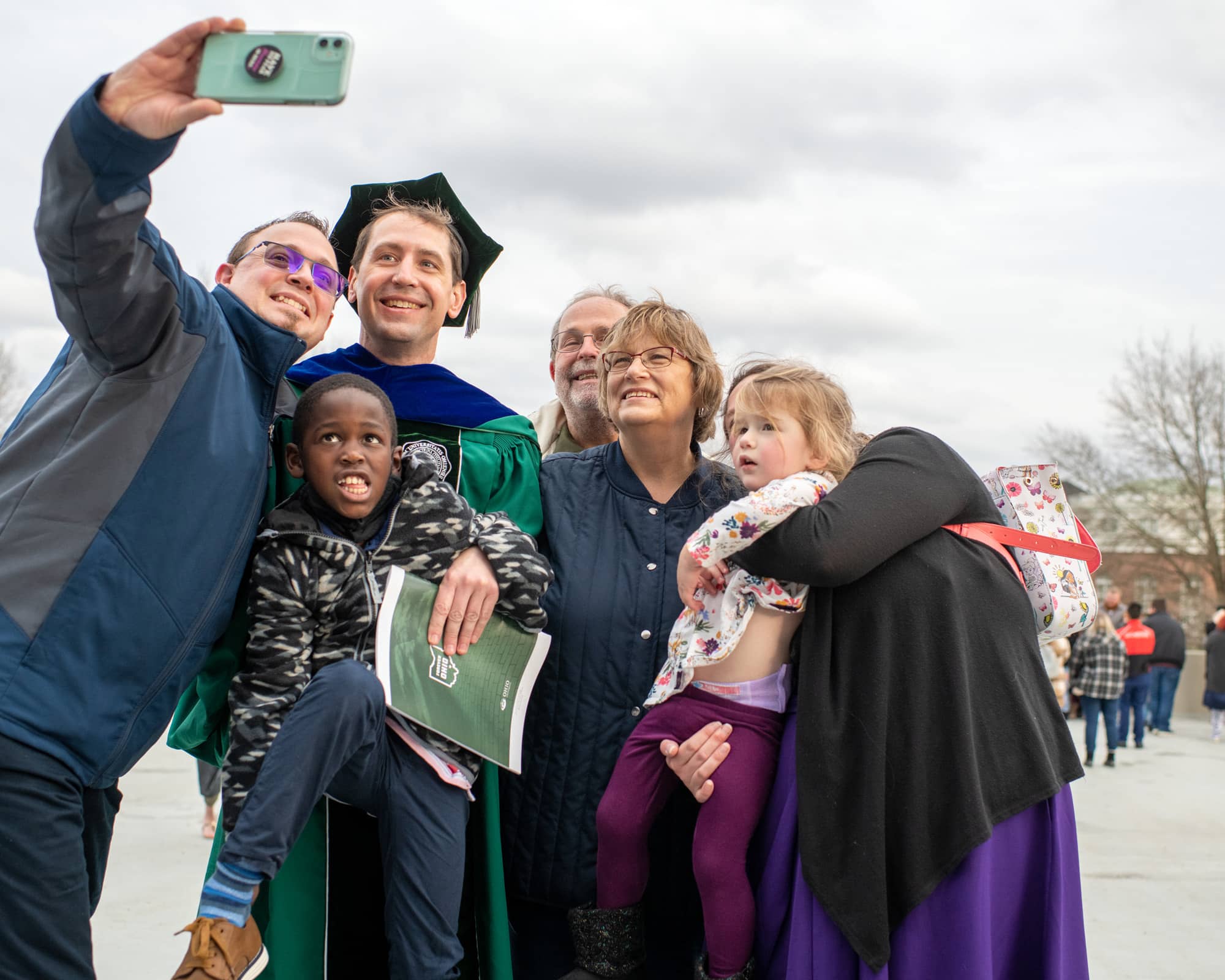 A recent graduate pauses for a photograph after the Fall Commencement 2021 at the Athens Campus. 