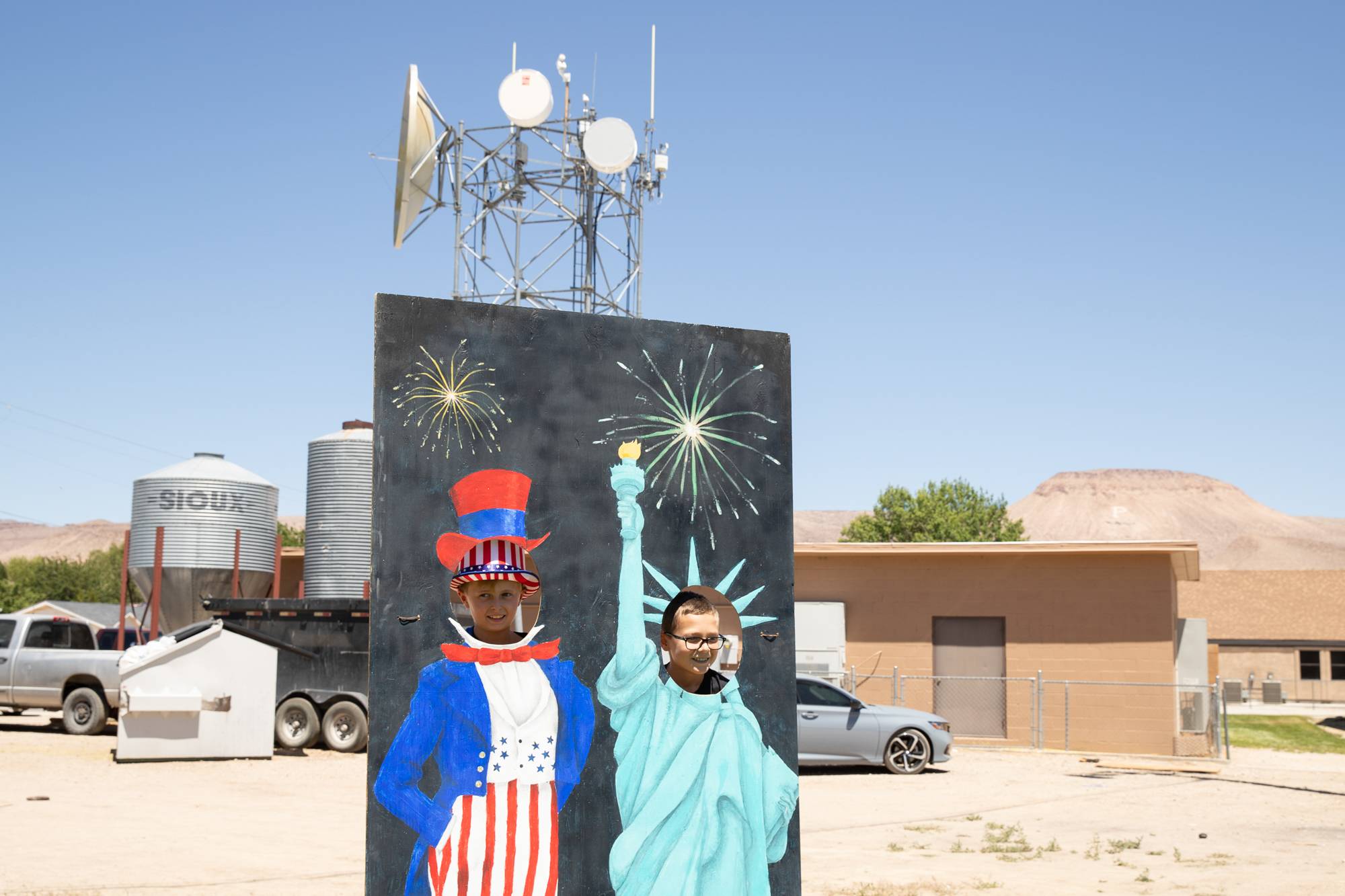 Two boys watch the Independence Day fair through the photo stand-in in Alamo, Nevada, on Monday, July 4, 2022.