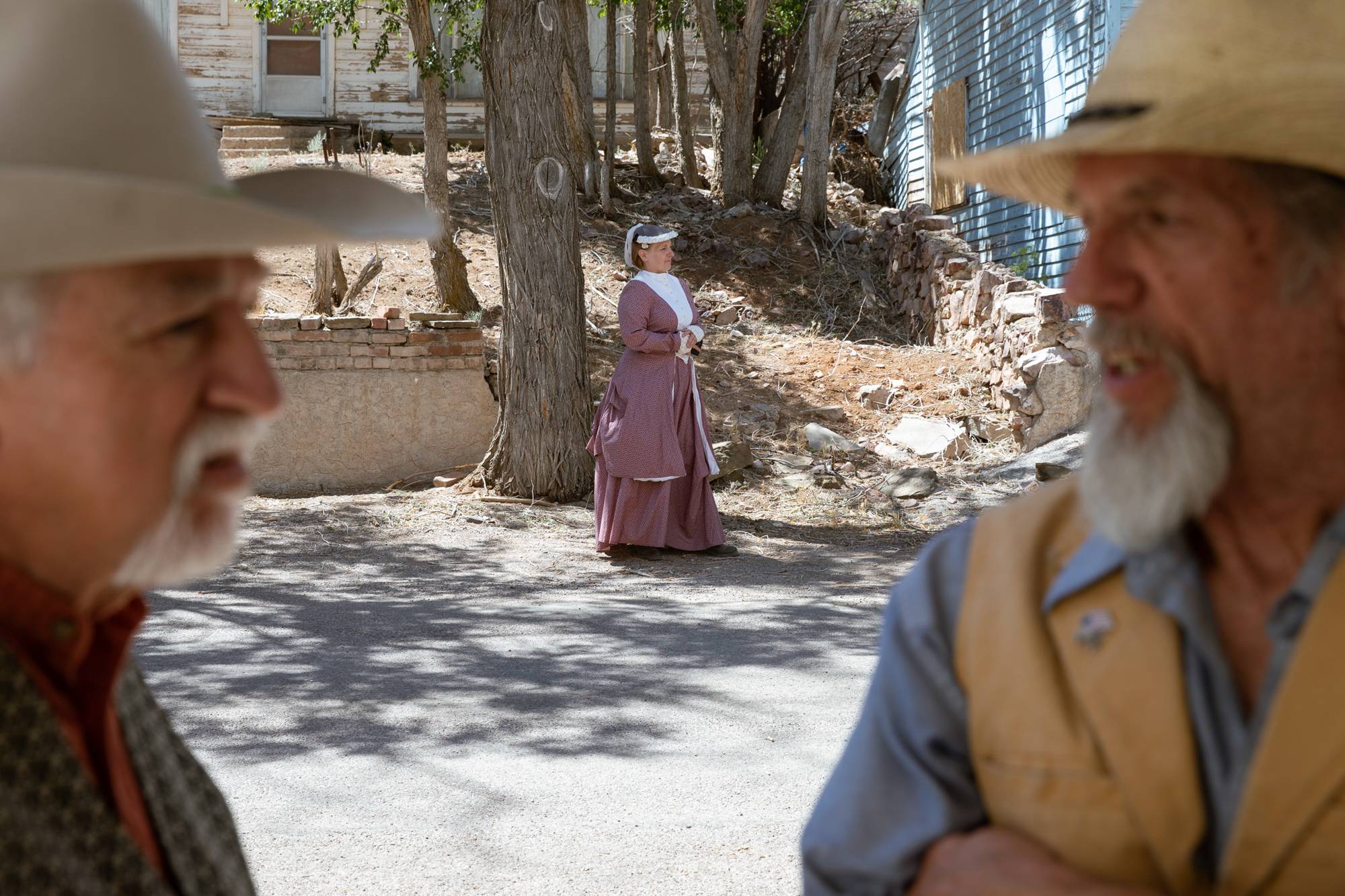 Sharron Faehling, background, Tim Umina, left, and Bill Merfy, right, wait outside of Christ Episcopal Church during the filming of an 1800s western documentary on Friday, June 24, 2022, in Pioche, Nevada.