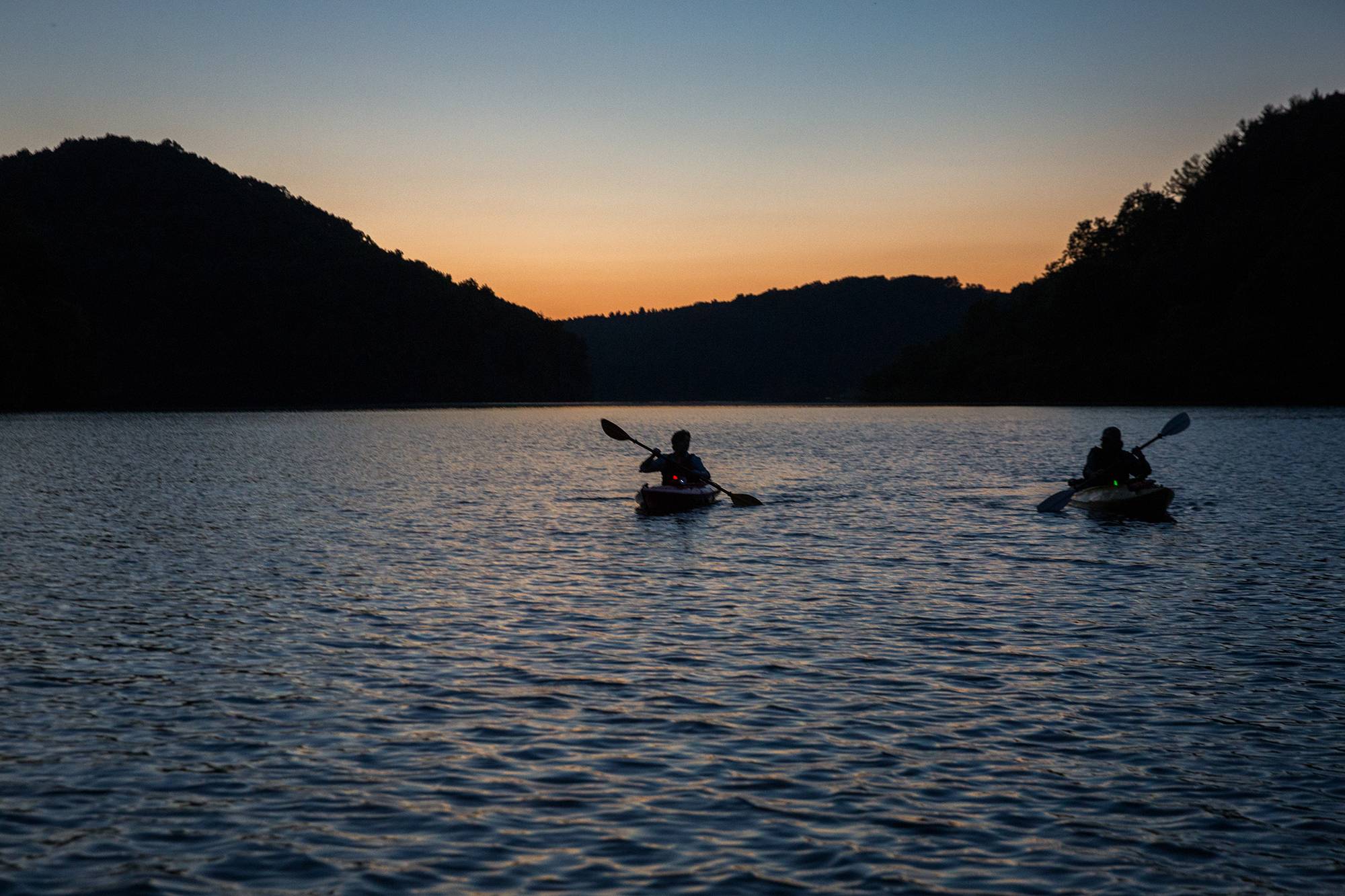 Kayakers paddle at night at Strouds Run State Park, just a few miles from the Ohio University campus. 