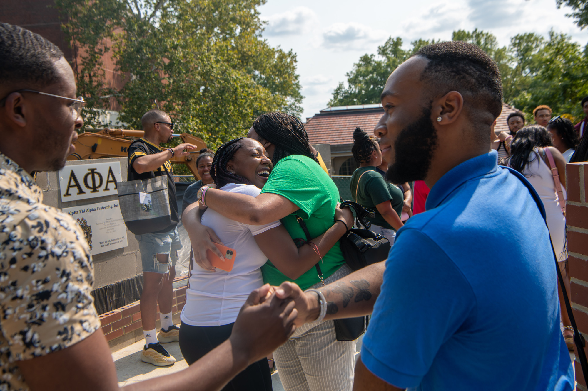 Students and alumni greet one another at the dedication of the National Pan-Hellenic Council Plaza on College Green.