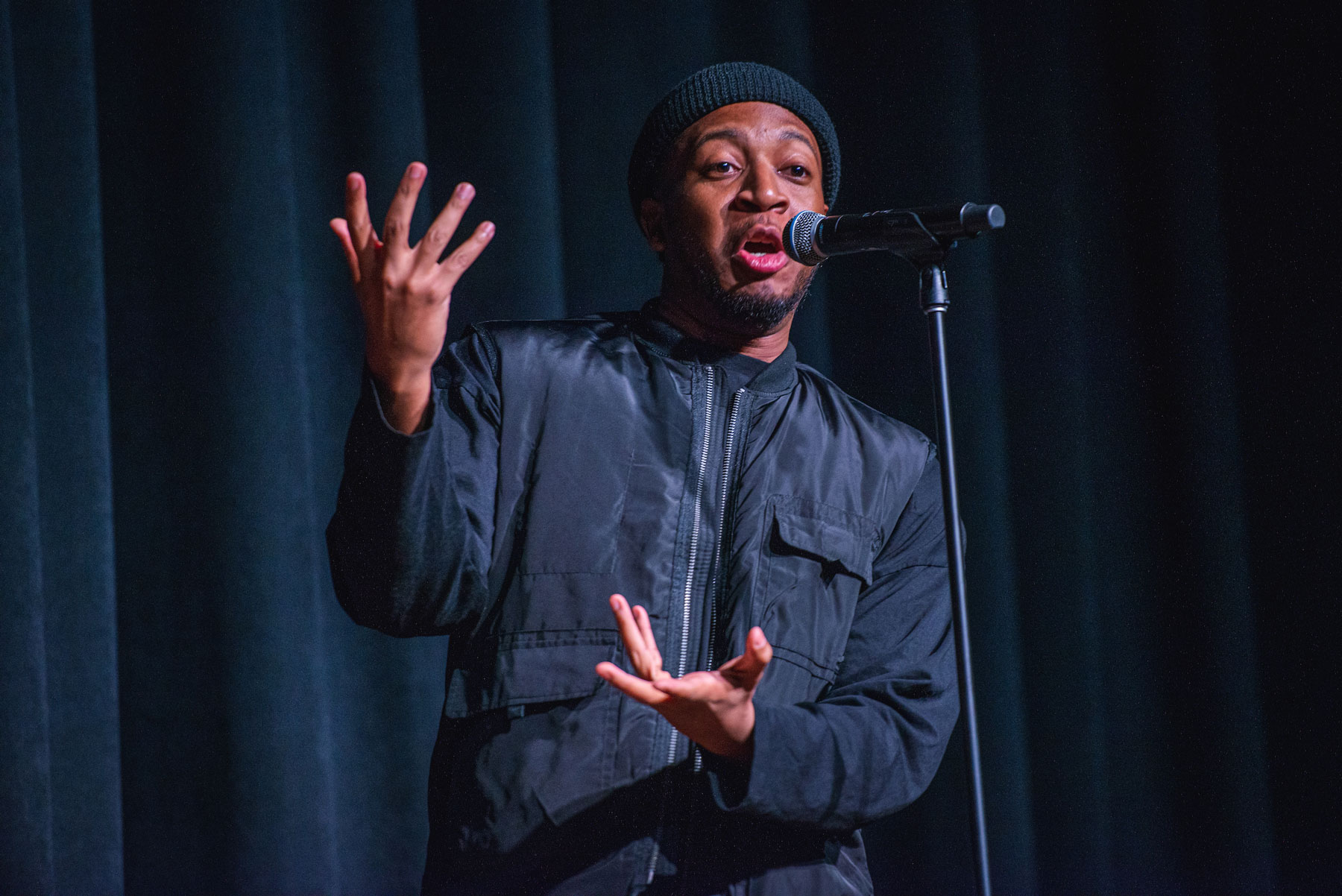 A man performing on stage during the MLK Jr. Day arts cypher event.