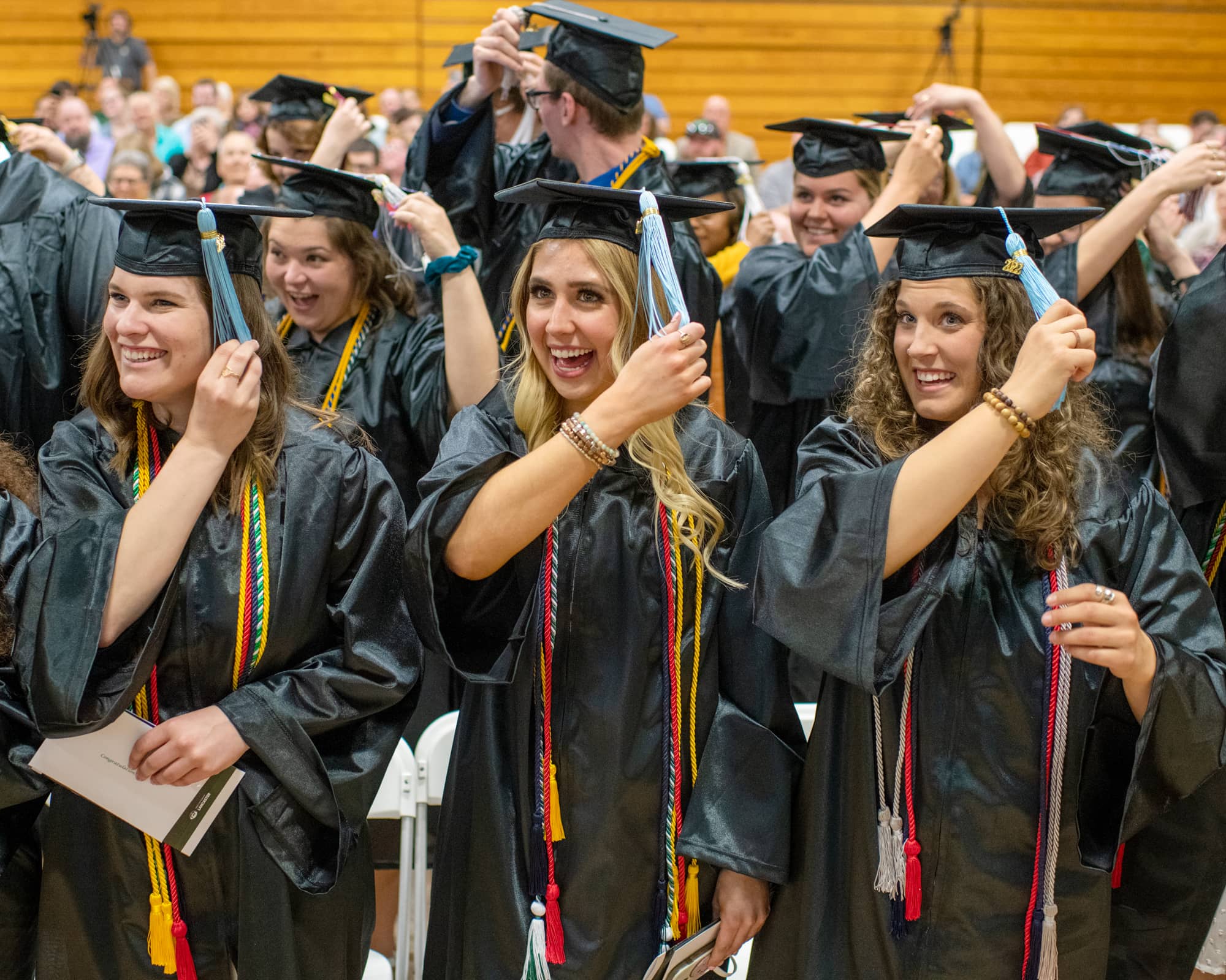 Students move their tassels to the left during a graduation recognition ceremony at the Lancaster Campus.