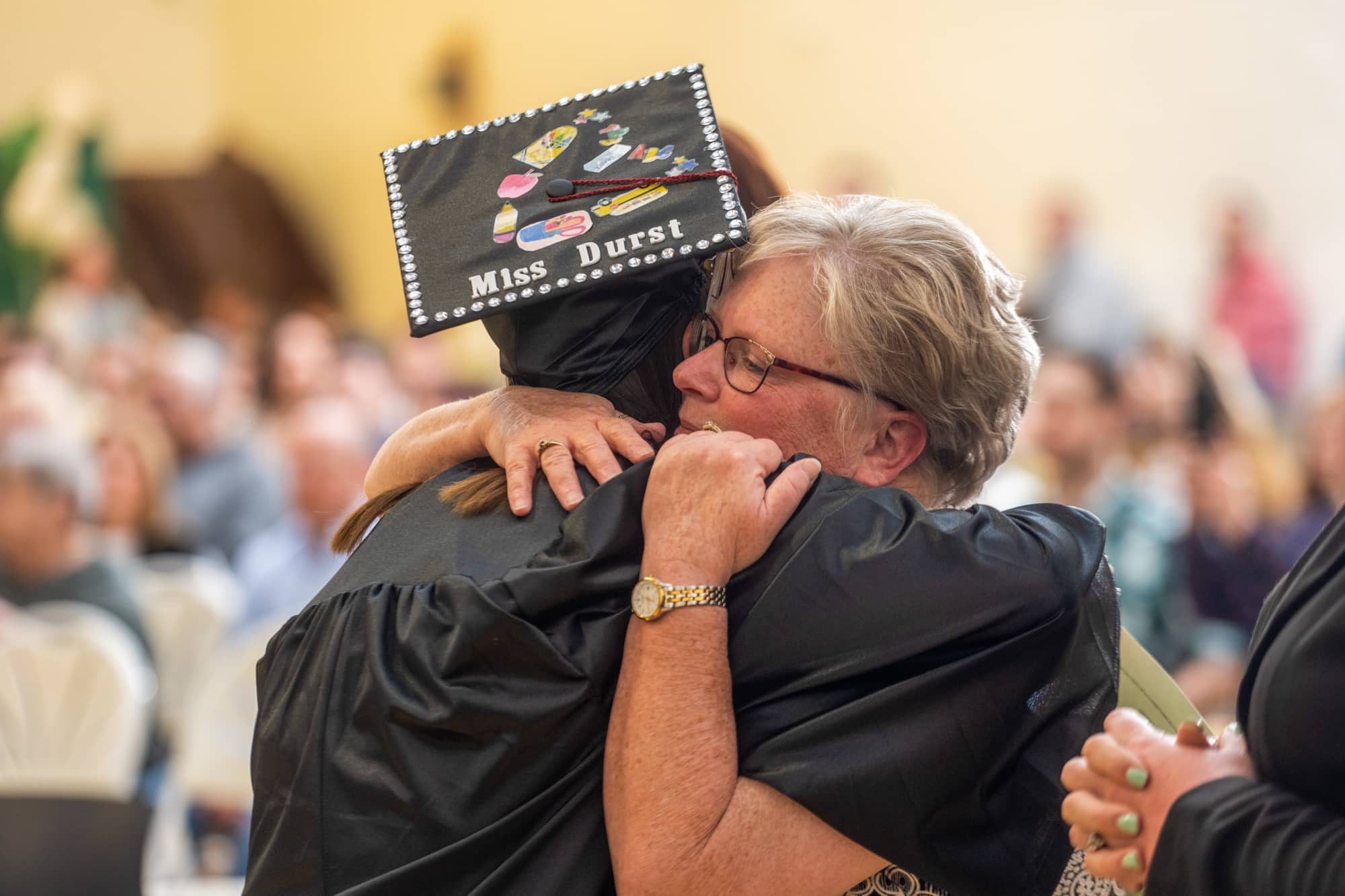 Dr. Teri Peasley, assistant professor of instruction and program coordinator for Early Childhood and Elementary Education, hugs a student during a graduation recognition ceremony at the Zanesville Campus.