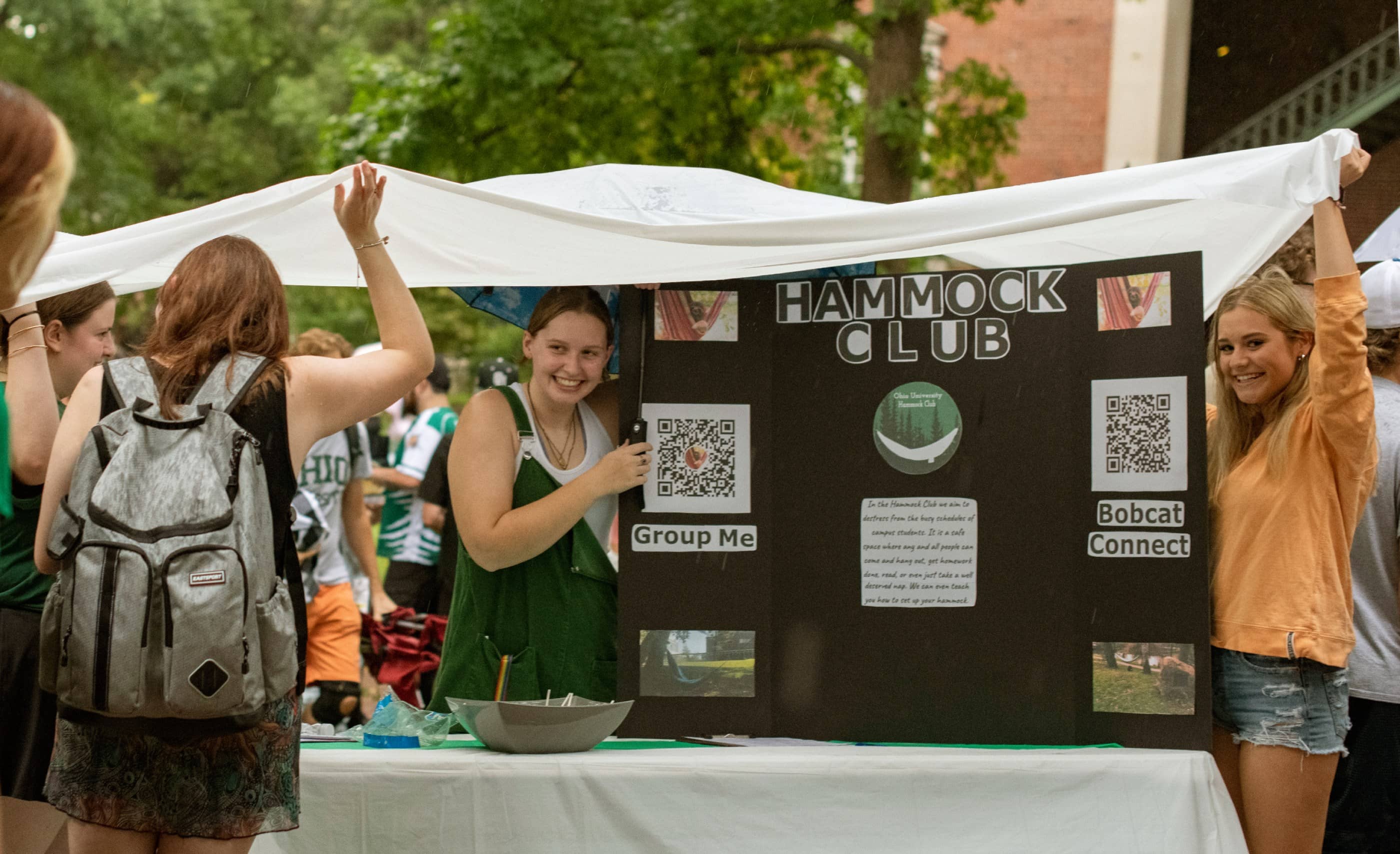 Members of the Hammock Club seek to avoid rain while recruiting members at the Student Organization Involvement Fair on College Green.