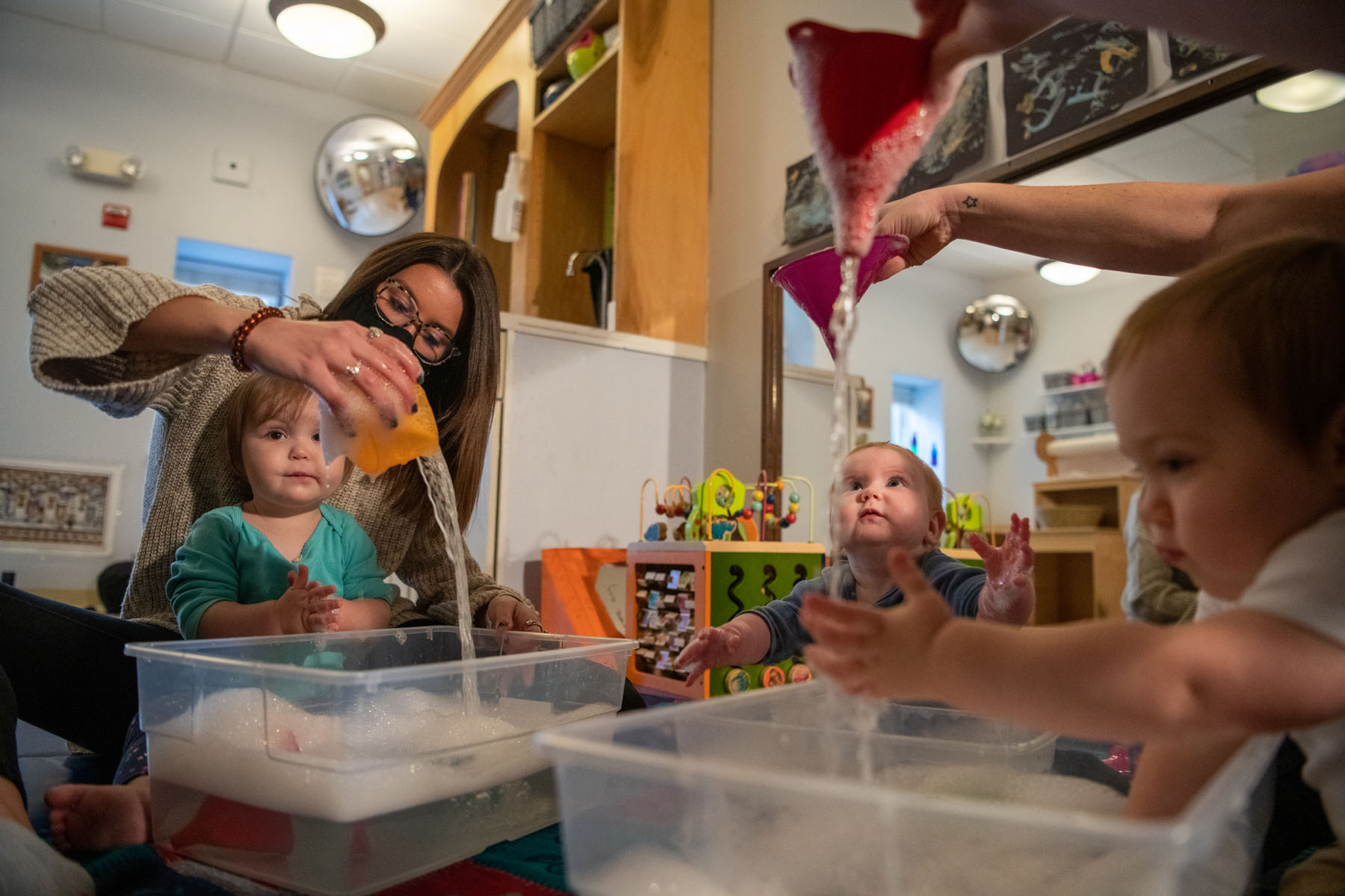 Childhood education major students working with small children in a classroom setting