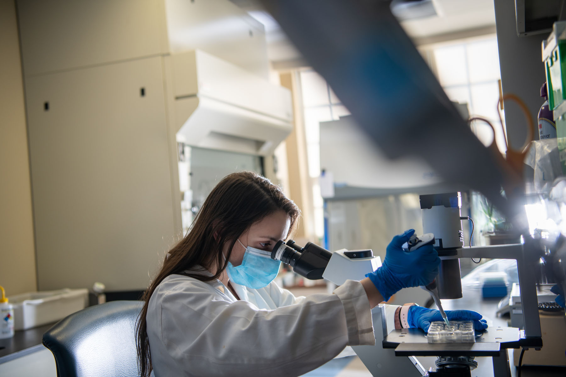 A student works with a pipette in a laboratory setting