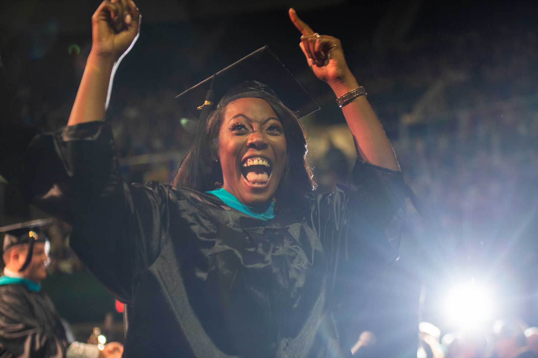 An excited student celebrates while walking to the stage at 2019 Fall Commencement
