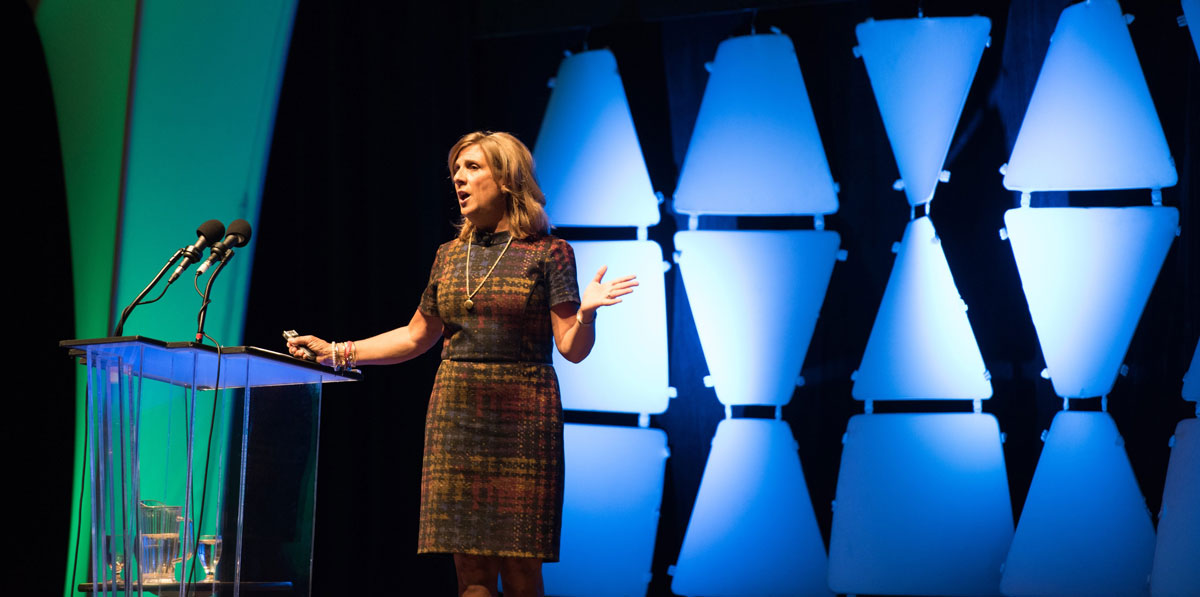 Nancy Frates Speaking about ALS in front of a podium at a conference