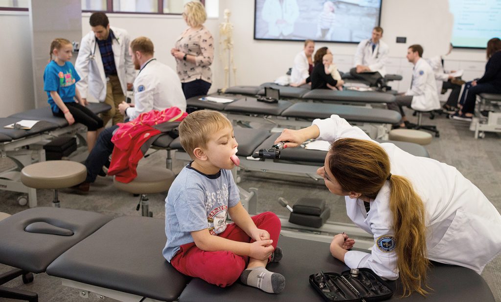 A medical student examines a child in a pediatric care at Ohio University's Cleveland campus