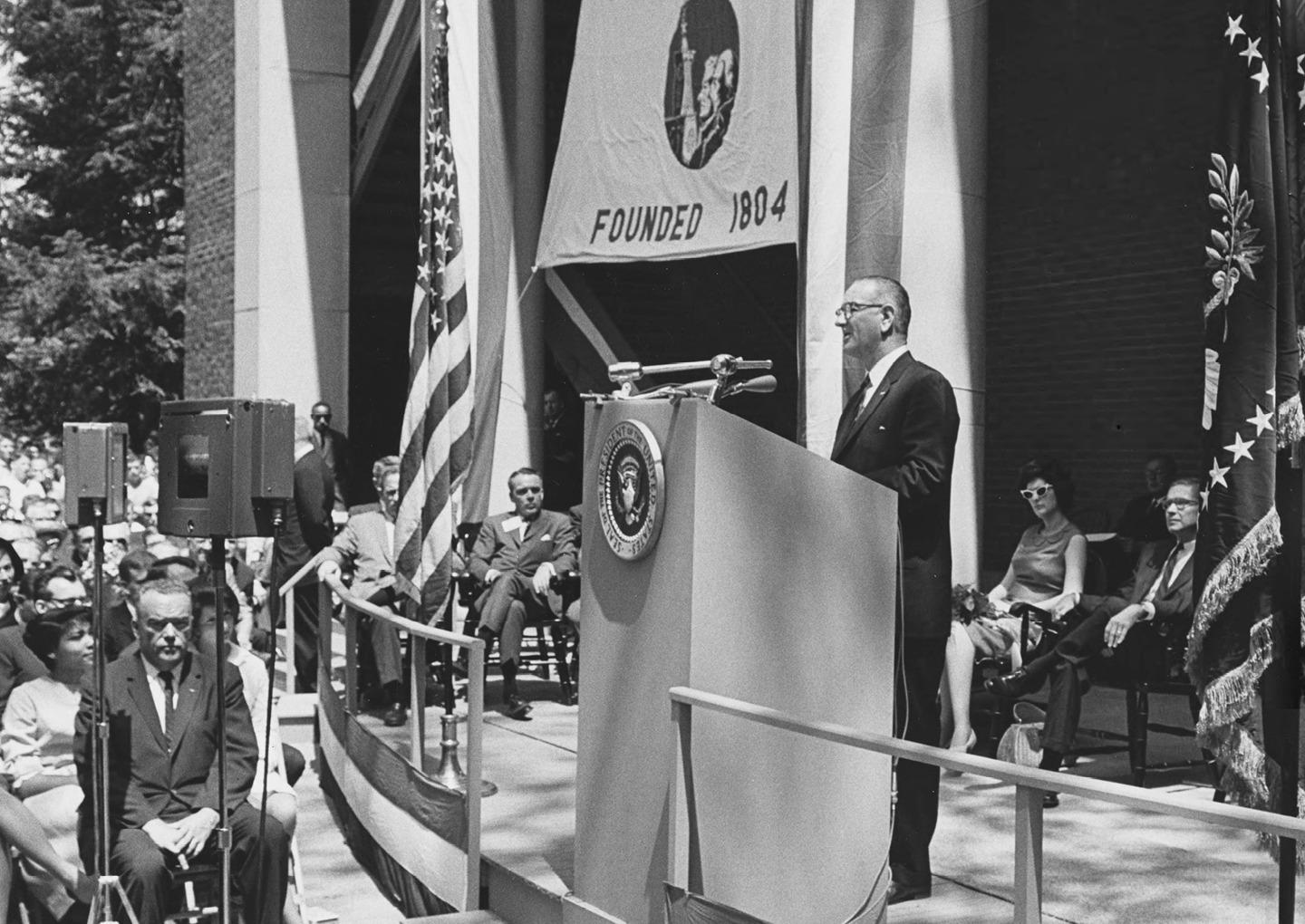 President Lyndon B. Johnson addresses a crowd estimated at 15,000 from the West Portico of Memorial Auditorium on May 7, 1964, as part of a five-state tour in support of his War on Poverty program. Bronze plaques on the West Portico commemorate the many distinguished guests and history makers who have visited campus – from Martin Luther King Jr. and Eleanor Roosevelt to several U.S. presidents. Photo courtesy of the Mahn Center for Archives and Special Collections